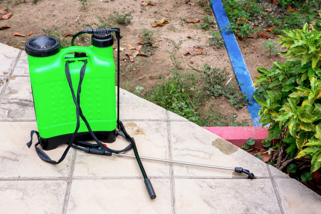 DIY pest control canister sitting next to Rockville garden.