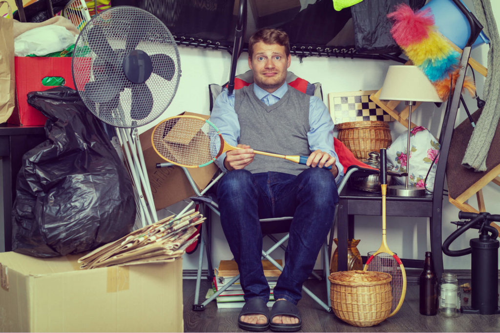 Reducing clutter in your Elkridge home is one way to prevent a mice infestation this coming winter. Maryland homeowner sits in cluttered home.